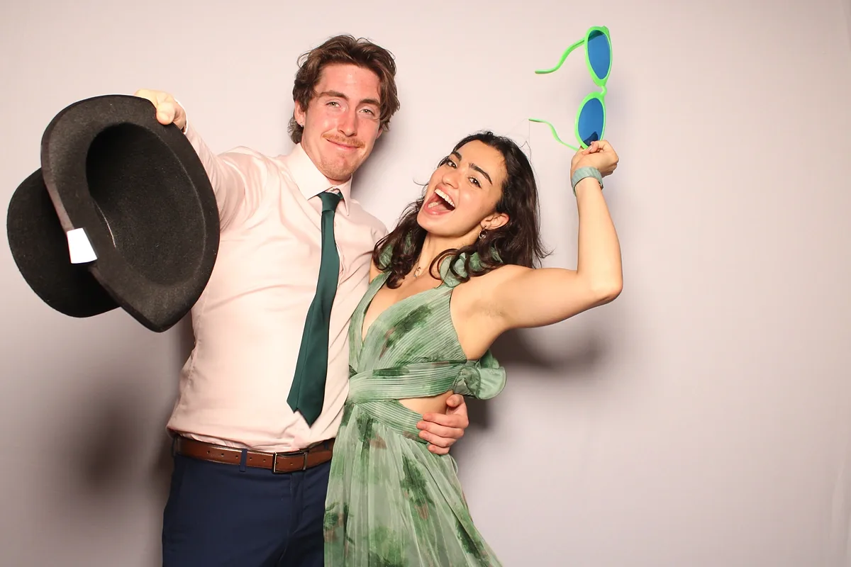 The couple with a top hat and novelty glasses at their own Calamus wedding photo booth