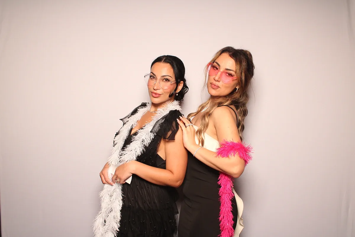 Two friends in white and pink boas striking a pose at the Magic Mirror in Jordan Station