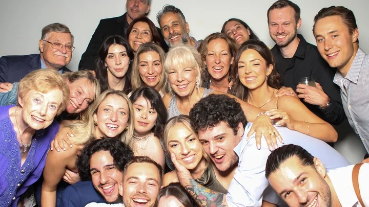 A large group of wedding guests posing together at the Magic Mirror photo booth